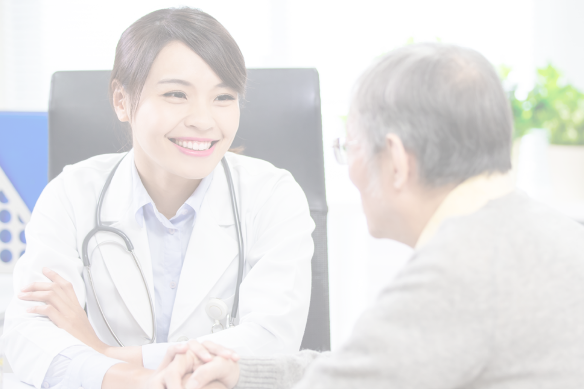 A doctor smiling at an older patient as they talk.